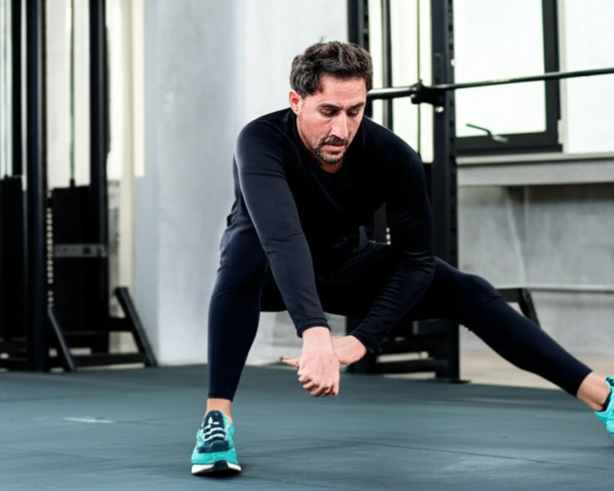Athlete performing dynamic warm-up exercises in a gym, such as arm circles or leg swings.
